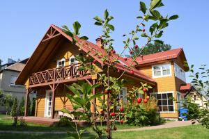 a house with a tree in front of it at Vila Liepa in Birštonas