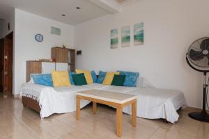 Schlafzimmer mit einem Bett mit blauen und gelben Kissen in der Unterkunft SeaFront Apartment Marsascala in Marsaskala