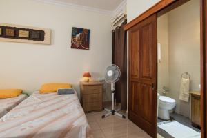 ein Schlafzimmer mit einem Bett und einem Ventilator sowie ein Badezimmer in der Unterkunft SeaFront Apartment Marsascala in Marsaskala