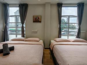 two beds in a room with two windows at Snooze TOO in Brinchang +12 photos