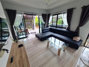 a living room with a blue couch and a glass table at D&A Paradise Villas in Koh Samui +19 photos