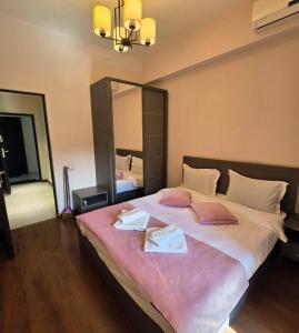 a bedroom with a large bed with two towels on it at Republic square LUXURY with balcony in Yerevan +6 photos