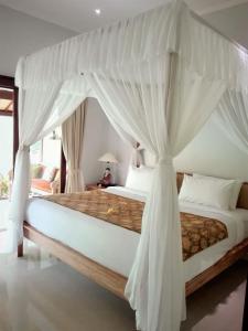 a bedroom with a large bed with a canopy at Villa Alam Surya Ubud in Ubud
