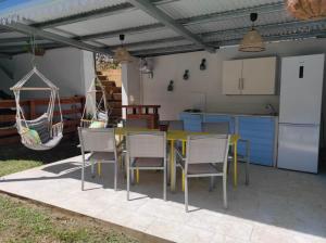 a patio with a table and chairs and a kitchen at La Palmeraie Créole in Sainte-Marie