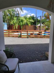 a patio with a fence and a bench and palm trees at La Palmeraie Créole in Sainte-Marie