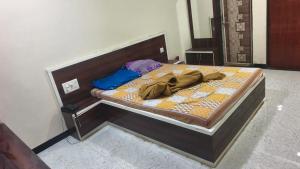 a bed with a wooden headboard with at Hotel Visava Restaurant & Lodging in Vaghunde Budrukh