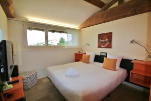 a bedroom with a large white bed with orange pillows at Teritoria Château de Besseuil in Clessé