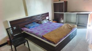 a bedroom with a large bed and a chair at Hotel Visava Restaurant & Lodging in Vaghunde Budrukh