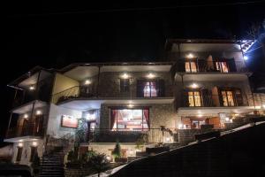 a large building with stairs leading up to it at night at Archontiko Velousi in Athamanía