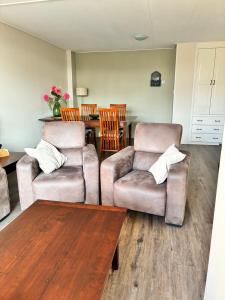 a living room with two chairs and a table at Vakantiewoning Meeuw in Hollum