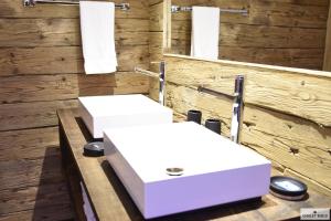 uma casa de banho com 2 lavatórios brancos e toalhas em Ferienhaus Chalet Riedji em Furna