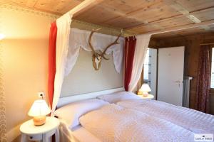 a bedroom with a bed with a canopy and two lamps at Ferienhaus Chalet Riedji in Furna