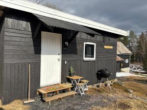 a black building with a grill and a picnic table at Musekroken in Elverum