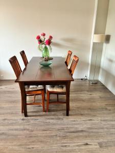 a table with chairs and a vase of flowers on it at Vakantiewoning Meeuw in Hollum