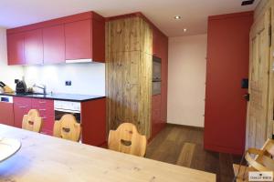 a kitchen with red cabinets and a wooden counter top at Ferienhaus Chalet Riedji in Furna