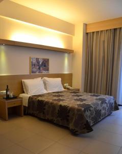 コモティニにあるKyridis Hotelのベッドルーム1室(大型ベッド1台、ナイトスタンド、テーブル付)