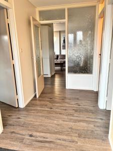 an empty hallway with wood floors in a building at Vakantiewoning Meeuw in Hollum +42 photos