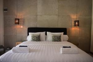 a large white bed with two towels on it at Blue Garden Yogyakarta in Yogyakarta