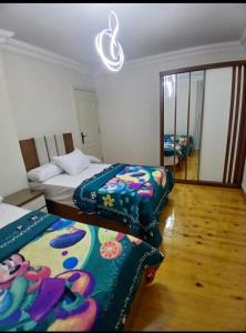 a bedroom with two beds with colorful blankets at سي فيو سان ستفانو in Alexandria