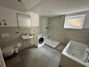 a bathroom with a washing machine next to a sink at Waldhaus in Affing +25 photos
