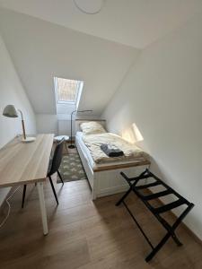a bedroom with a bed and a desk and a table at Waldhaus in Affing
