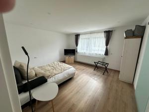 a bedroom with a bed and a chair and a window at Waldhaus in Affing
