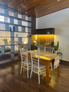 a dining room with a wooden table and chairs at Triolet Bed and Breakfast in Shillong