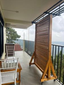 a balcony with a table and a chair and a view at Triolet Bed and Breakfast in Shillong