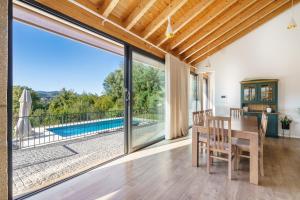 a dining room with a table and a view of a pool at Casa das Letras - Turismo rural in Ponte da Barca