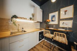 a kitchen with a sink and a counter with chairs at L'Eure de Luxure Loveroom Suite in Normandy in Évreux