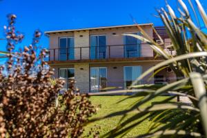 a house with a palm tree in front of it at Radazul Apart de Mar & Campo in Chapadmalal