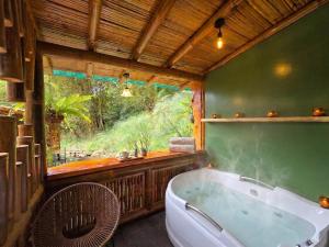 a bathroom with a tub and a large window at Senz Glamping - Mindo in Mindo