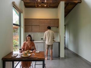 a man and a woman standing in a kitchen at Senz Glamping - Mindo in Mindo