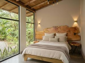 a bedroom with a large bed and a large window at Senz Glamping - Mindo in Mindo
