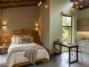 a bedroom with a large bed and a table at Senz Glamping - Mindo in Mindo