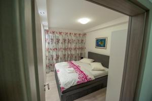 een kleine slaapkamer met een bed en een spiegel bij Apartmani Marin in Split