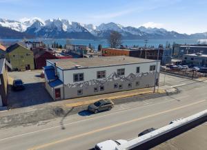 a white building with a sign on it next to a road at Hotel North in Seward