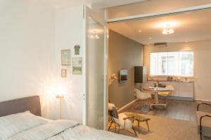 a bedroom with a bed and a table and a kitchen at De Eindhovenaar City Apartments in Eindhoven