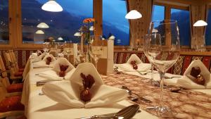 une grande table avec des nappes blanches et des verres à vin dans l'établissement Gasthof Thanner, à Brandberg