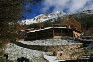 a house in the mountains with snow on it at Hotel Rural Abejaruco in Cuevas del Valle