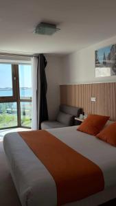 a bedroom with a large bed and a window at Logis Hôtel Le Rochelois in La Rochelle