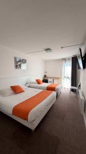 a hotel room with three beds and a television at Logis Hôtel Le Rochelois in La Rochelle +35 photos