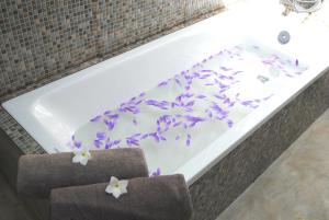 a bath tub with purple and white flowers on it at Wasantha Garden Hotel Restaurant & Ayurvedic Treatment in Weligama