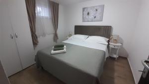 a bedroom with a bed with two towels on it at apartmani G&M in Bibinje