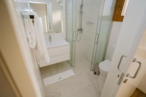 a bathroom with a shower and a sink and a toilet at Elya Beach Luxury Suites in Ayios Theodhoros +37 photos