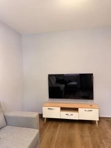 a living room with a tv and a couch at The Green Loft in Fushë-Arrëz