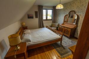 a bedroom with a bed and a dresser and a mirror at Agroturystyka u Oli in Smolany Dąb