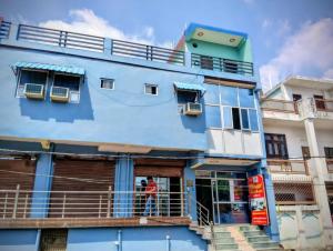 a man standing outside of a blue building at Virasat Guest House in Lucknow