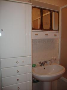 La salle de bains est pourvue d'un lavabo et d'un placard avec un miroir. dans l'établissement Apartamento Artur, à Lousã