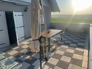 a patio with a table and an umbrella at Gite Les Hirondelles in Langatte